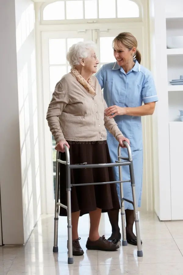 Caregiver assisting elderly woman with a walker
